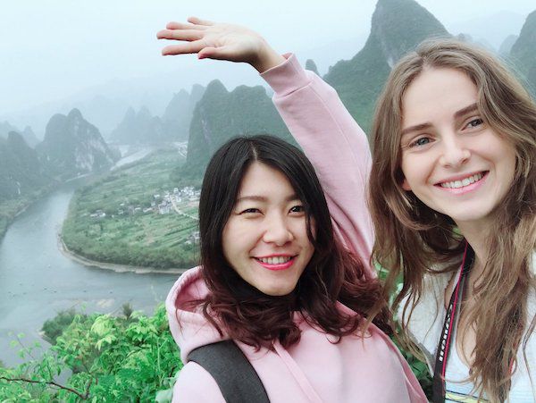 Twee CLI-studenten poseren voor karstgebergte buiten Guilin, China