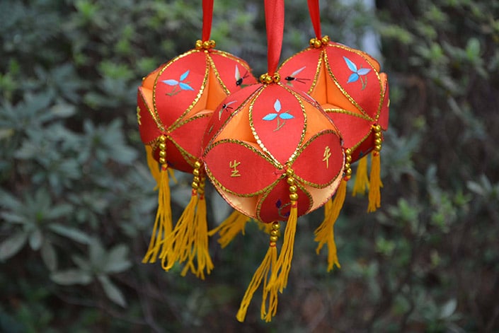 three orange embroidered balls