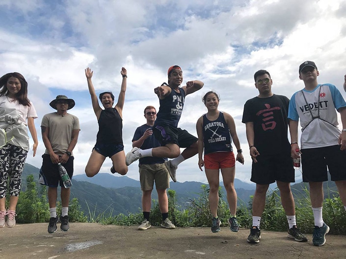 Los estudiantes del CLI saltan en el aire con las montañas de fondo