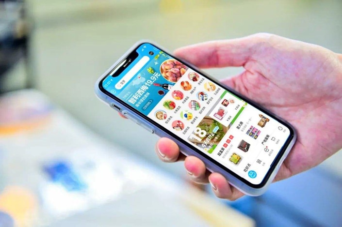 a hand showing a phone open to a Chinese website