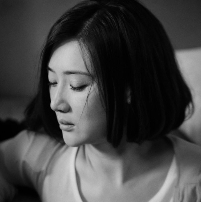 una foto en blanco y negro de una mujer china con aspecto triste tras sufrir la presión de ajustarse a los cánones de belleza en China