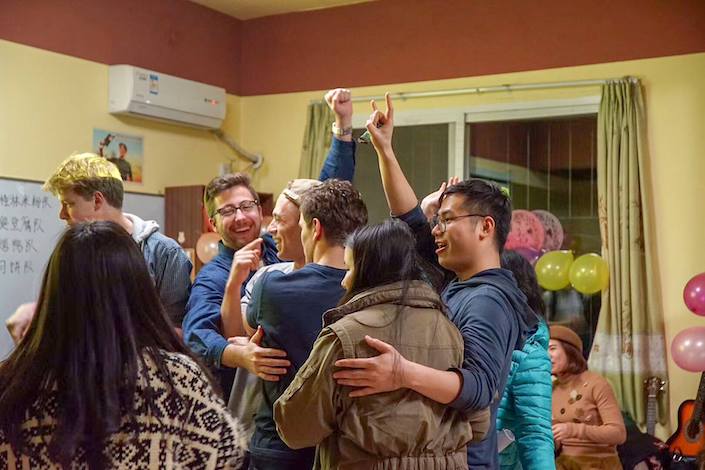 CLI teachers and students hugging and celebrating during a cultural exchange activity