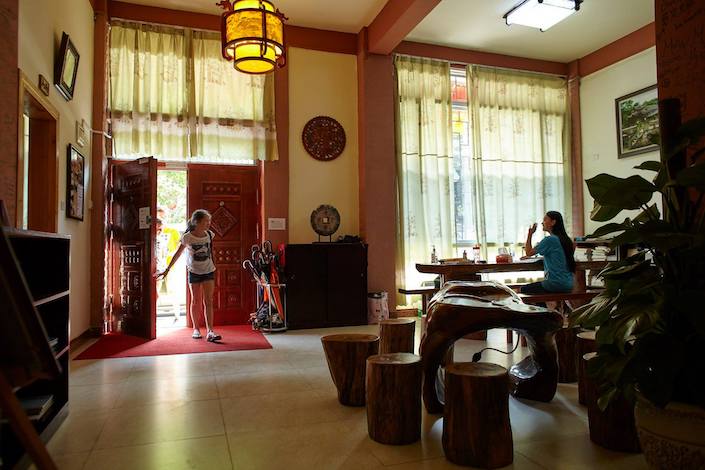 a young CLI student walking through the CLI Center door and greeting a CLI teacher