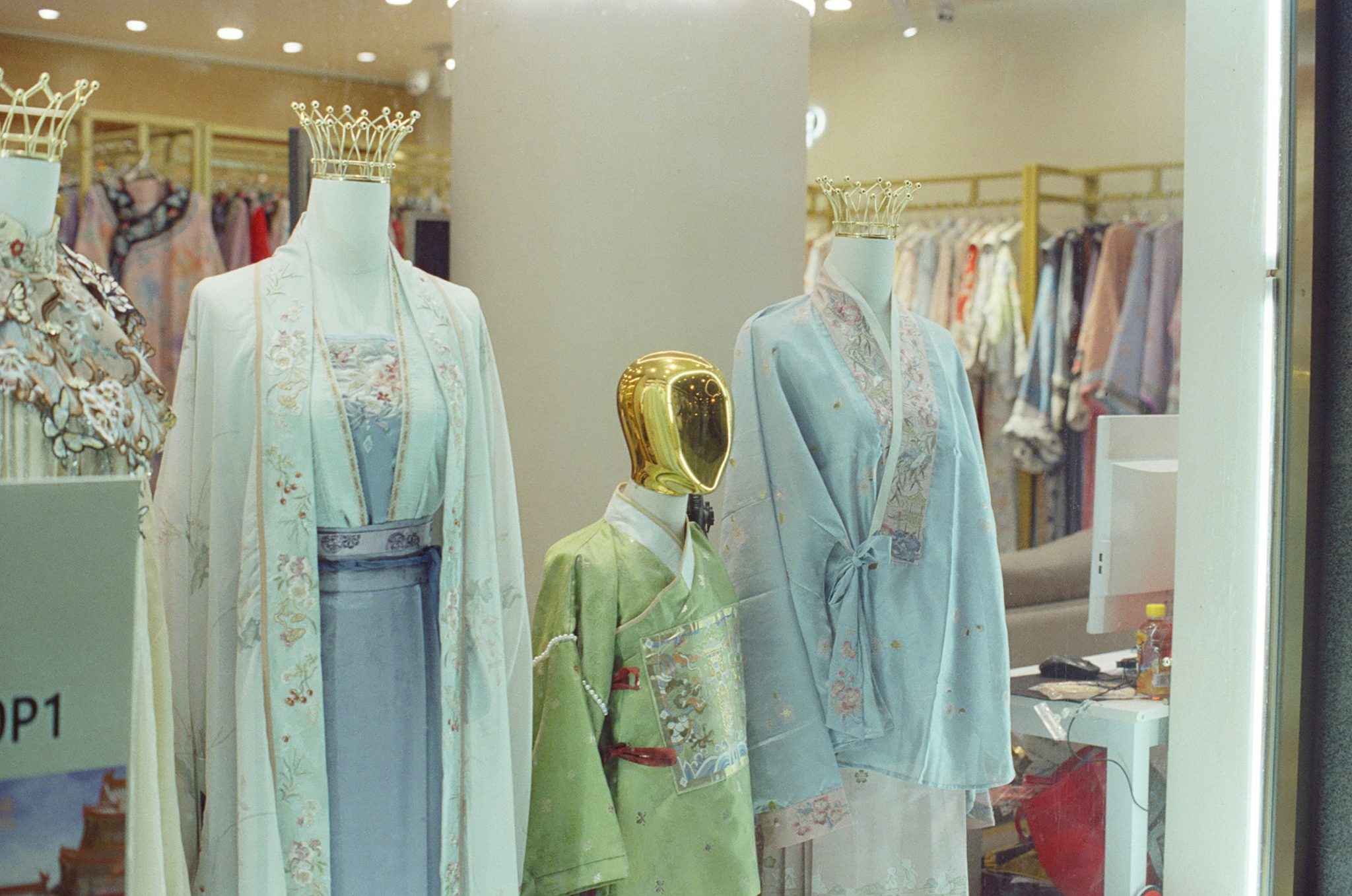 Mannequins display traditional chinese clothing in a store.
