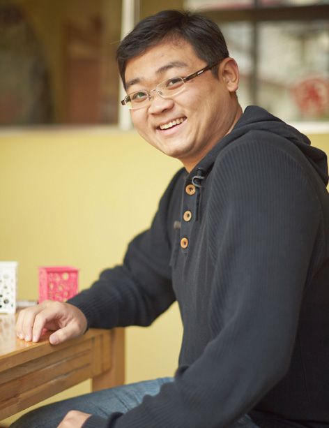 Membre du personnel de l'Institut de langue chinoise posant pour le portrait d'un membre de l'équipe