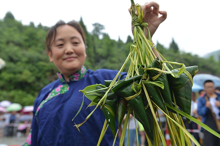 드래곤 보트 축제를 축하하기 위해 zongzi를 만드는 중국 사람들