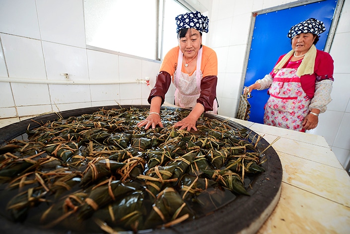 Chinese people making zongzi to celebrate the dragon boat festival