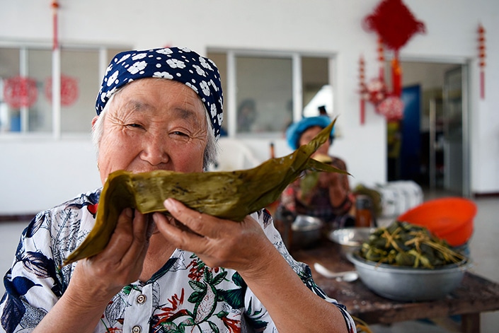 Los chinos hacen zongzi para celebrar el festival del barco del dragón