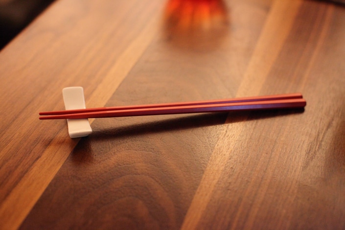 a pair of chopsticks sitting on a wooden table 