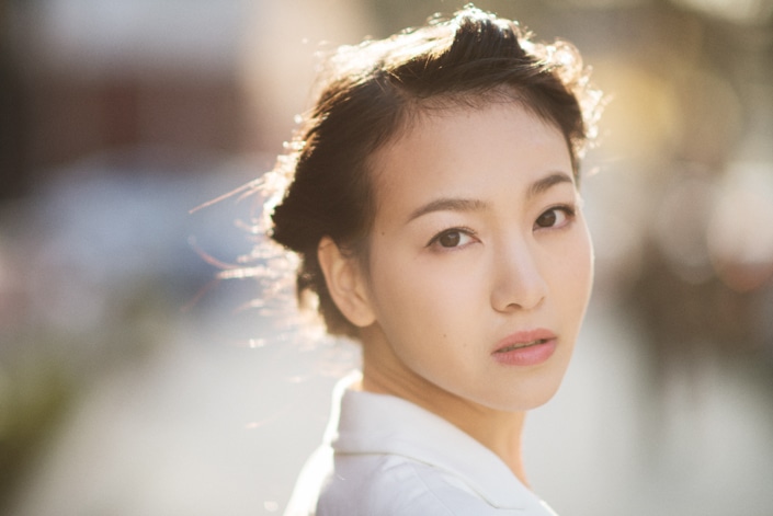 una fotografía de una joven china mirando por encima del hombro, demostrando los estándares chinos de belleza