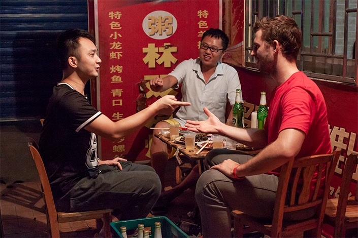 a group of friends using Chinese numerology to play a drinking game