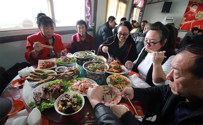 中国家庭围坐在餐桌旁使用谚语