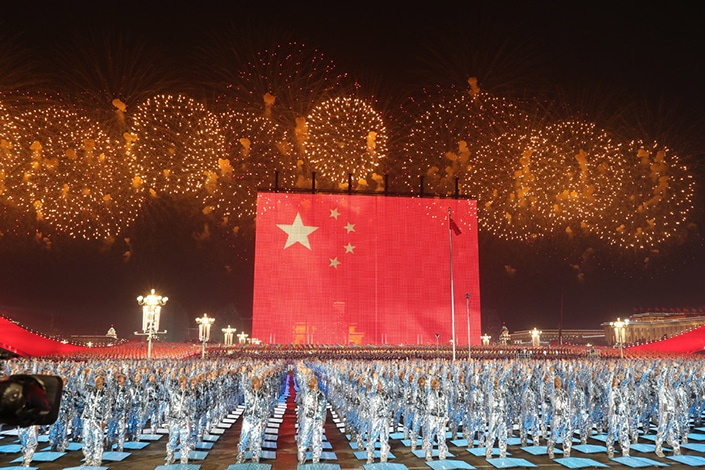 一面巨大的红色中国国旗，背景是金色烟花，庆祝中国国庆节