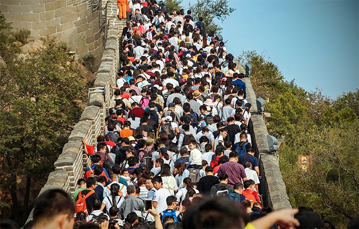 中国国庆假期期间，一群游客在长城上行走