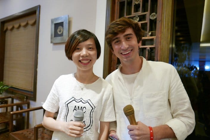 un estudiante de CLI y un maestro sosteniendo micrófonos preparándose para grabar podcasts chinos