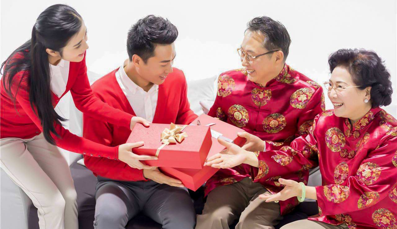 A Chinese family exchanges gifts wrapped in red paper