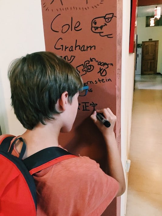 a young CLI student writing his name in Chinese