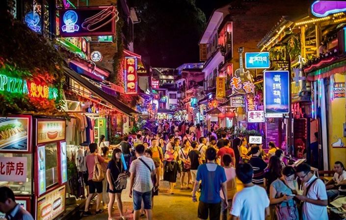 Yangshuo travel guides guide visitors on a walk through the Yangshuo night market