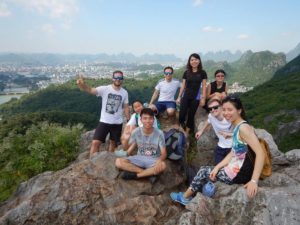 A group rests on rocks at a hilltop lookout over Guilin