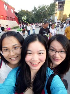 Three friends take a selfie on a crowded street