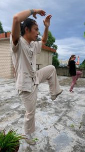 A man holds a martial arts stance on a rooftop