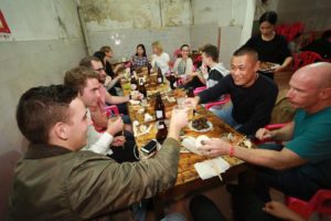 A big group shares a meal at a long restaurant table