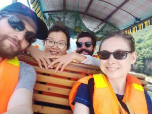 Friends in life jackets take a selfie on a river boat