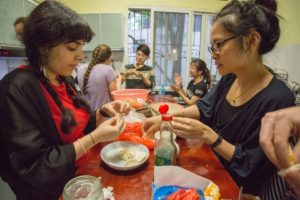 Two women make dumplings together at a table