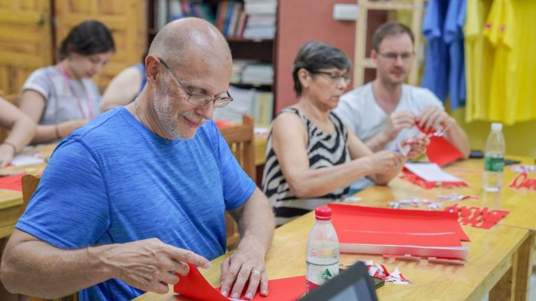 Pliage et découpage de papier rouge à une longue table