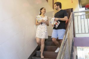 A teacher and student walk down the Center stairs carrying books