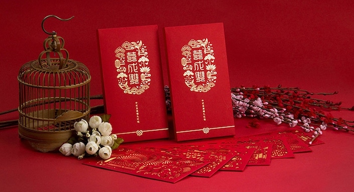 two Chinese red envelopes and a small bird cage