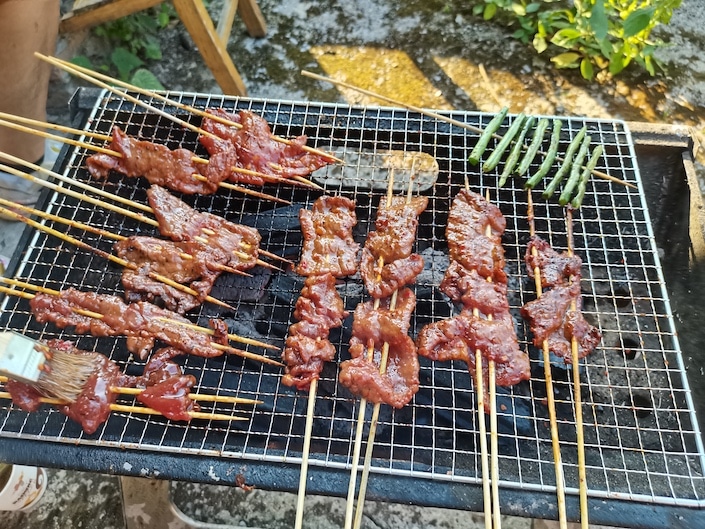 meet skewers cooking over a grill