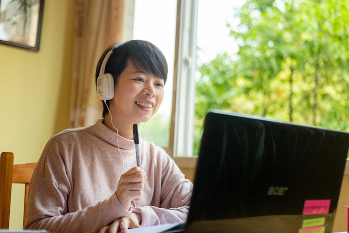 chinese tutor teaching student using her laptop