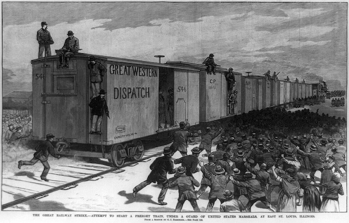 a print of the Great Railway Strike of 1886 showing railway cars on tracks with a crowd of people swarming around them on the ground and several men sitting on top of them