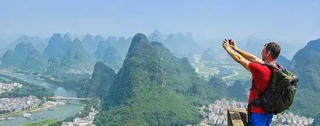 Traveler overlooking the karst mountains and river landscape of Guilin, China