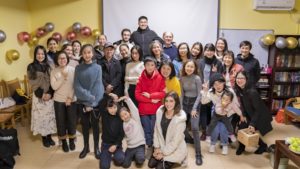 A large group poses with balloons in a room