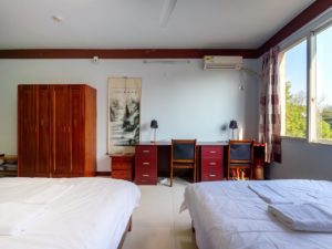 A room with two beds, desks and a wardrobe