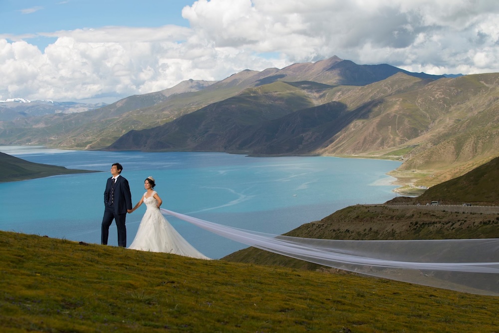 Newlyweds in front of a lake in Tibet
