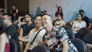 Audience members laugh together during an indoor event