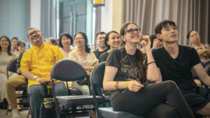 Audience members listen from the front rows during an indoor event