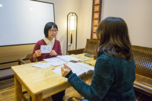 A teacher holds up a flashcard during a one-on-one class