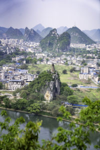 A city and river framed by dramatic karst peaks