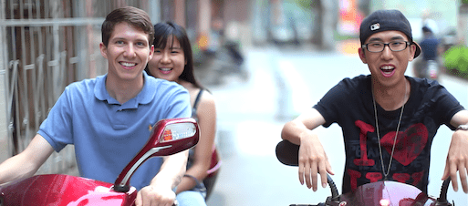 CLI students riding scooters on a street in Guilin, China