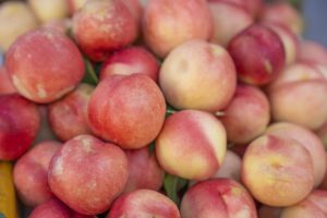 Red and yellow peaches piled high at an outdoor market