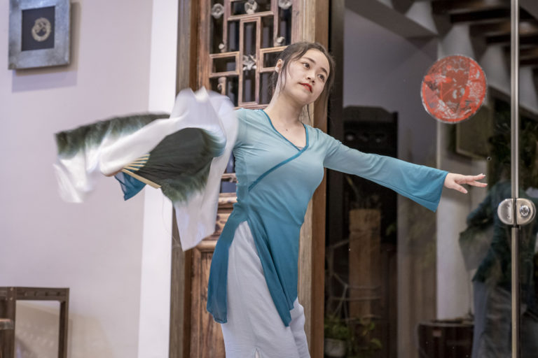 Une danseuse en robe bleue fluide