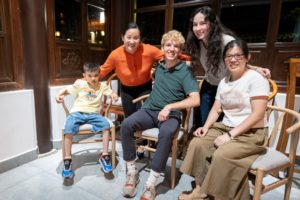 A small group poses together on chairs in a wood-paneled restaurant