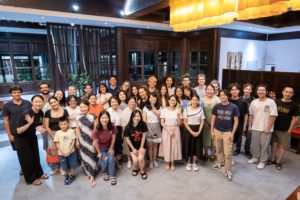 A large group poses together for a photo in a restaurant dining room