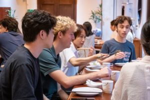People talk and share food around a busy dinner table
