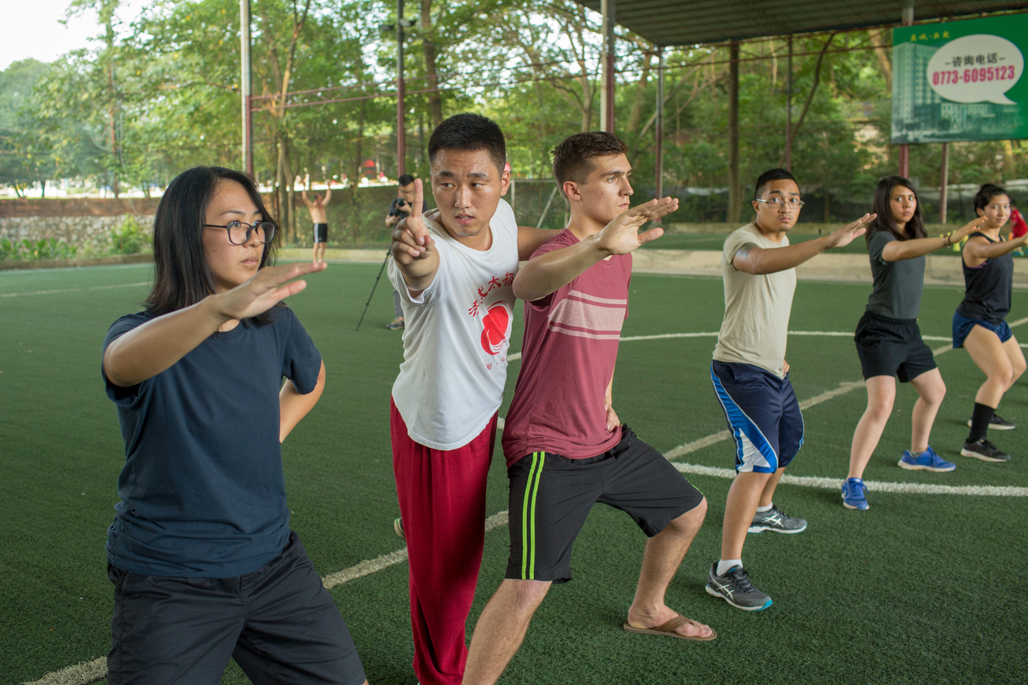 Students practicing taichi on a soccer field