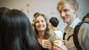 Guests chat and laugh while holding drinks